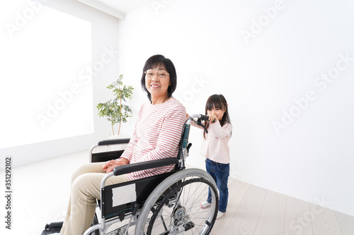車椅子に乗るおばあちゃんと女の子 © maroke