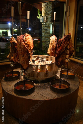 Brazilian style beef ribs Barbecue grill on skewers around fire stove at a churrascaria steakhouse in Sao Paulo, Brazil.