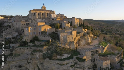 French houses and buildings built into rock. Gordes, France at sunrise from aerial perspective
