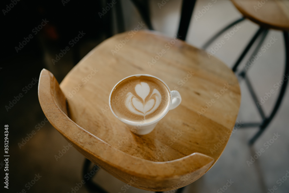 bonita taza de café debajo de una mesa de madera y encima de una silla bonita taza de café debajo de una mesa de madera y encima de una silla
