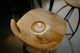 bonita taza de café debajo de una mesa de madera y encima de una silla