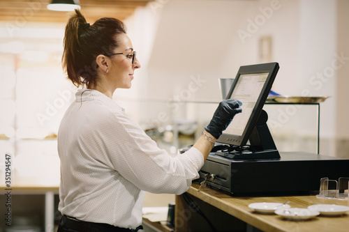 entrepreneur working at a POS terminal in a small coffee shop