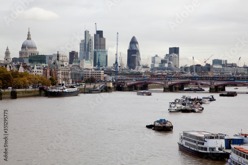 the River Thames looking east towards St.Pauls cathedral and the city with a boats in the foreground 