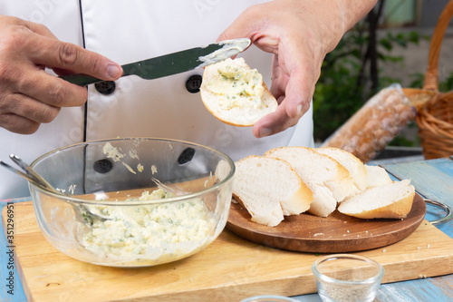 Chef spread garlic butter on slice bread /