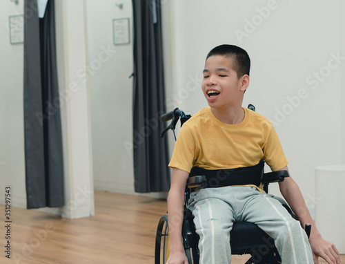 Disabled child on wheelchair having fun shopping for clothes, He is in front of fitting room,Special children's lifestyle,Life in the education age of special need kids,Happy disability kid concept.