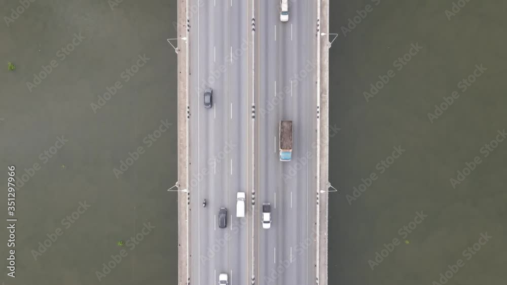 Aerial drone view of the bridge across the river with moving cars.