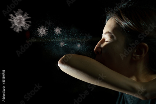Woman coughing or sneezing in her elbow. Concept of stop spread of the virus. Spray infection photo