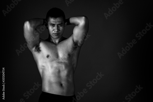 A strong Asian man raised his arms to show his strong and beautiful muscles from exercise