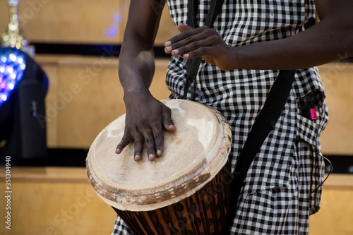 Detail of african american man musician playing traditional drums at home. Online music class concept. Leisure learning musical instruments. Rhythm and blues style. Ethnic multicultural traditions.