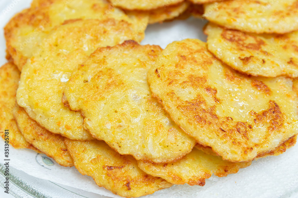 Homemade fried potato pancakes on a transparent plate. Homemade fried potato pancakes on a transparent plate.