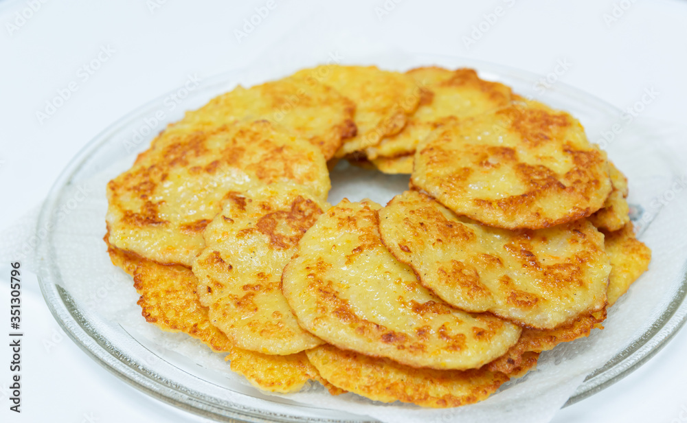 Homemade fried potato pancakes on a transparent plate. Homemade fried potato pancakes on a transparent plate.