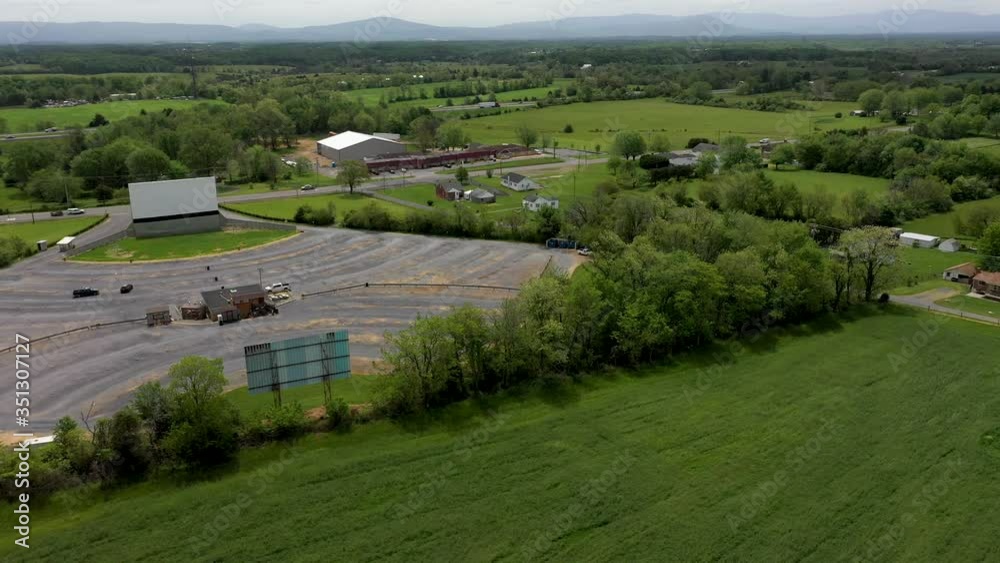 Aerial orbit of a drive-in movie theater with two separate screens.