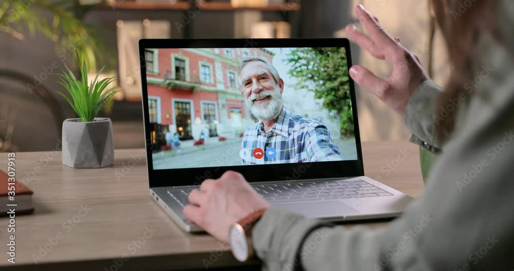 Laptop screen with video conference between girl and her grandfather. Woman videochatting with old Caucasian man and giving thumb up while sitting indoors. Online call. Conversation concept Laptop screen with video conference between girl and her grandfather. Woman videochatting with old Caucasian man and giving thumb up while sitting indoors. Online call. Conversation concept