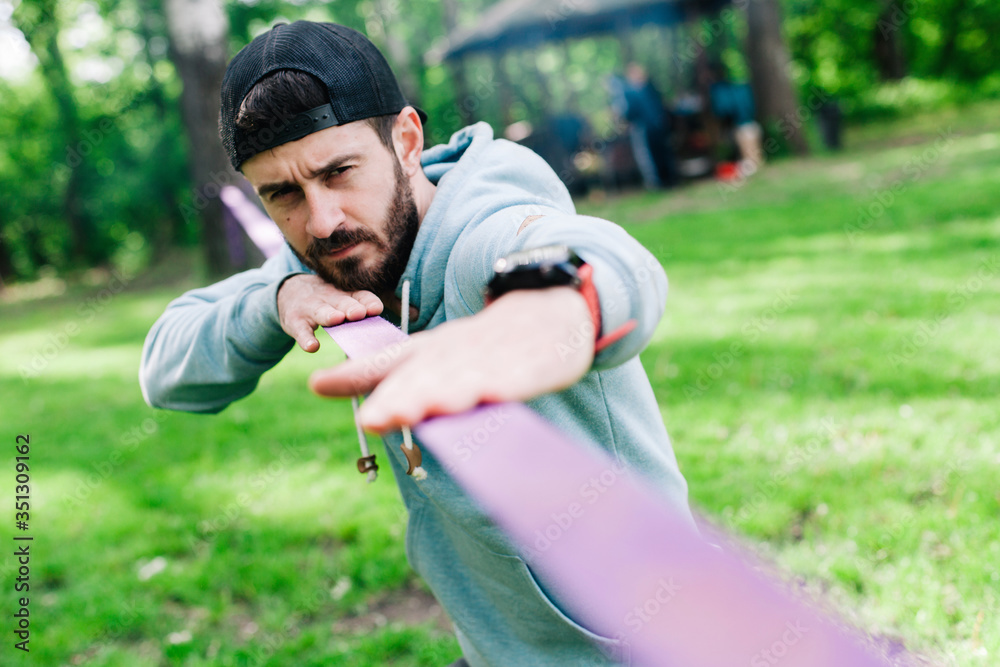 Setting up slacklining equipment in the park Setting up slacklining equipment in the park