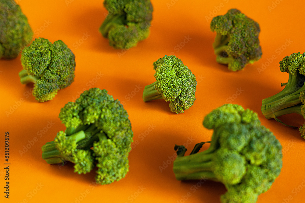slices of green broccoli cabbage on a bright isolated orange background slices of green broccoli cabbage on a bright isolated orange background