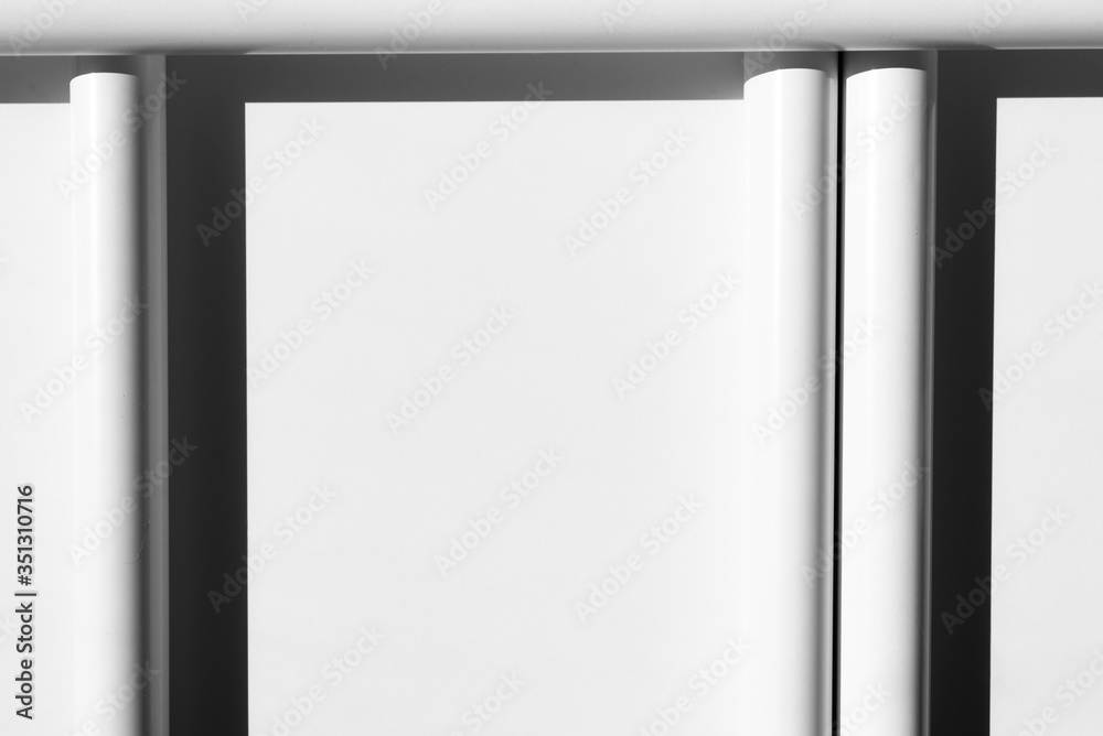White tubes arranged in geometric, regular lines. Modern background. White, grey and black. Copy space. White tubes arranged in geometric, regular lines. Modern background. White, grey and black. Copy space.
