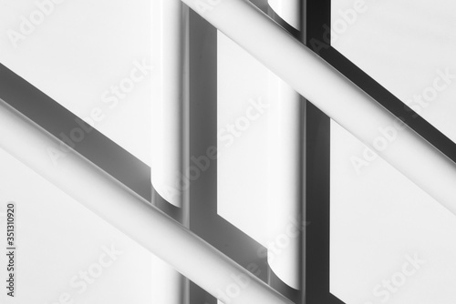 White tubes arranged in geometric, regular, parallel lines. Modern background. White, grey and black.