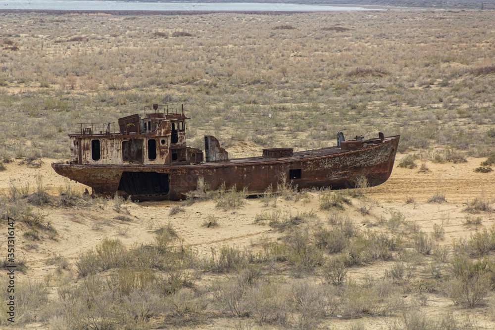 Fototapeta premium Rusty ship at the ship graveyard in former Aral sea port town Moynaq (Mo‘ynoq or Muynak), Uzbekistan