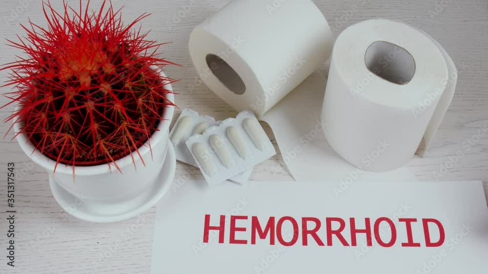 Putting of paper with word HEMORRHOID on table with cactus
