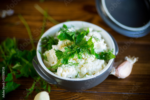 salted homemade cottage cheese with garlic and herbs in a bowl