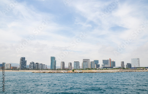 View of Barceloneta Beach from the sea and buildings in the background. Barcelona waterfront. © Dmytro
