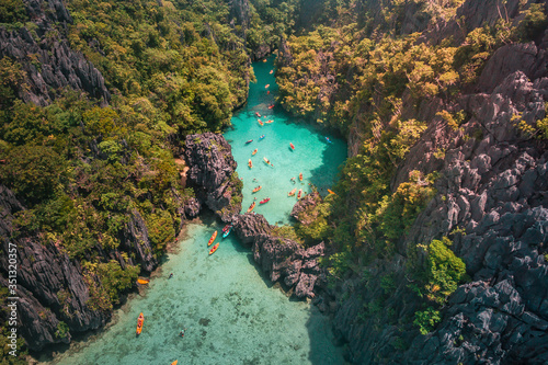 An aerial view of tourists kayaking going in and out in the Small Lagoon to Big Lagoon in Maniloc Island, El Nido, Palawan, Philippines. photo