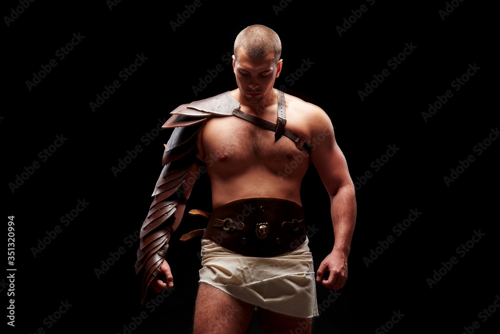 Fototapeta premium Gladiator with sword and armor on a black background