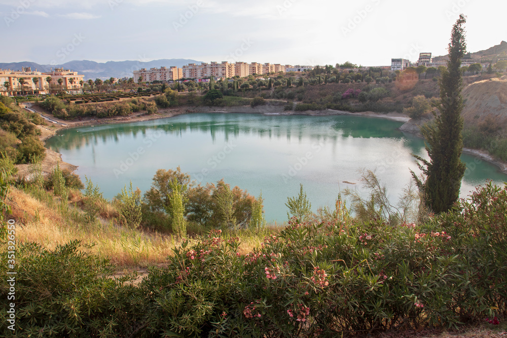 Image of a lagoon surrounded by vegetation in the middle of the city 
