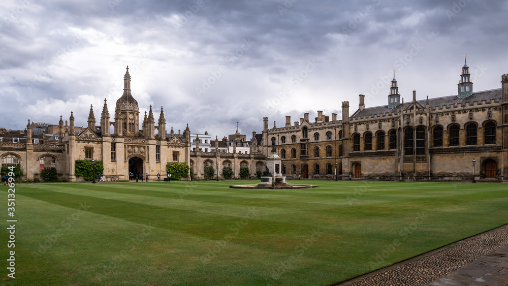 The historic buildings of the University of Cambridge. Green lawn and beautiful sky.