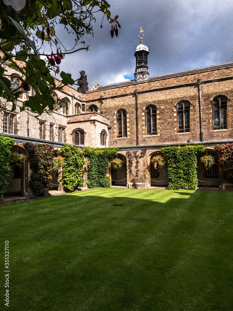 The historic building of the University of Cambridge. Green lawn and blue sky.