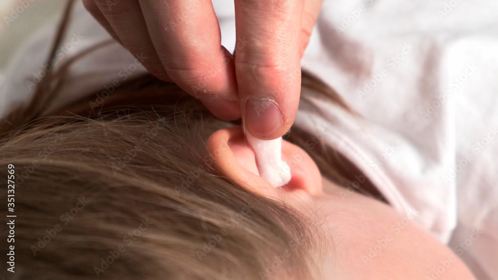 Naklejka premium Put in sick ear by white cotton swab.