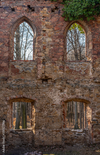 Ancient brick wall with windows in an abandoned nature setting