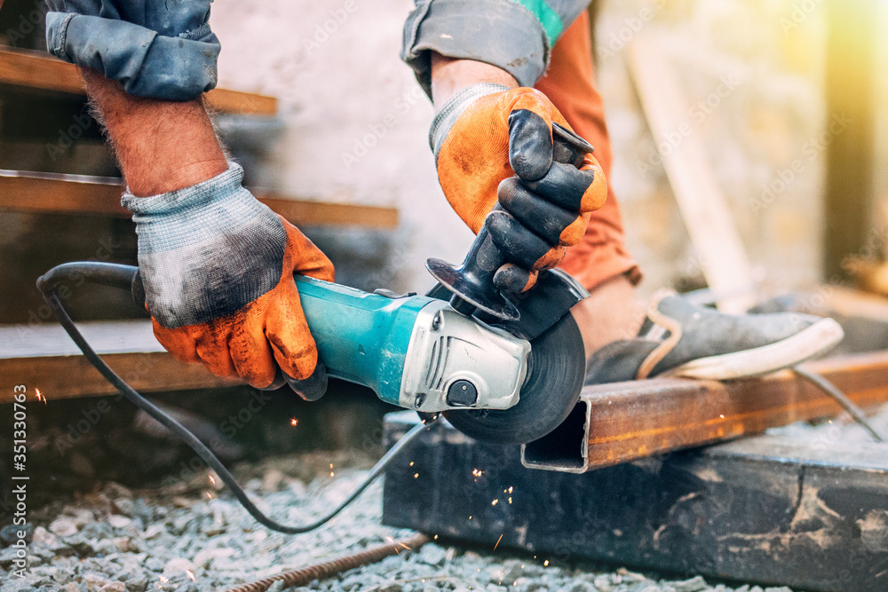 a man is sawing metal with an angle grinder.
