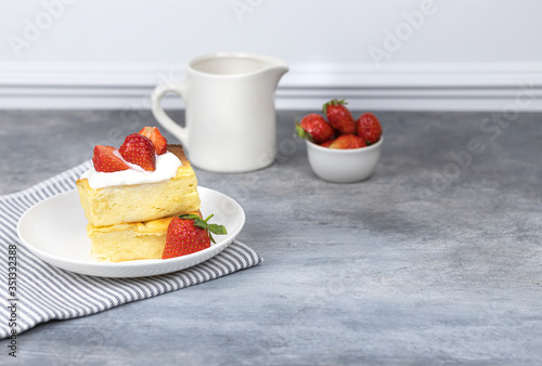 cottage cheese casserole with cream and strawberries on a white plate