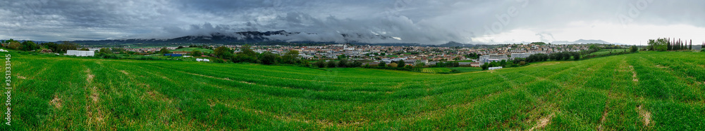 Panoramic view of a small old European village near the mountain, in the clouds, before the thunderstorm