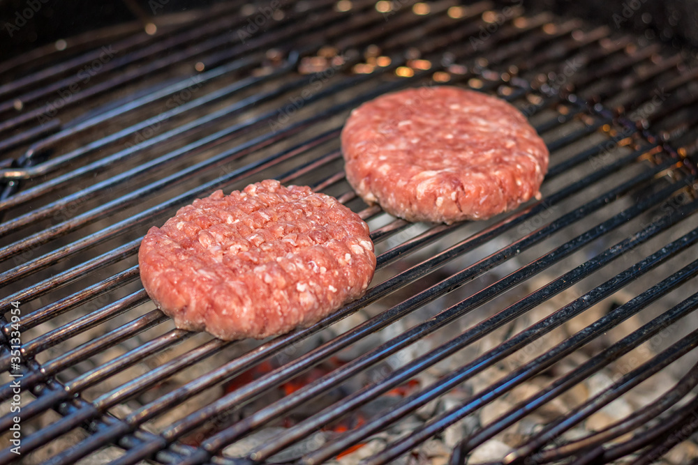 grilled meat - two burgers on an outdoor grill grilled meat - two burgers on an outdoor grill
