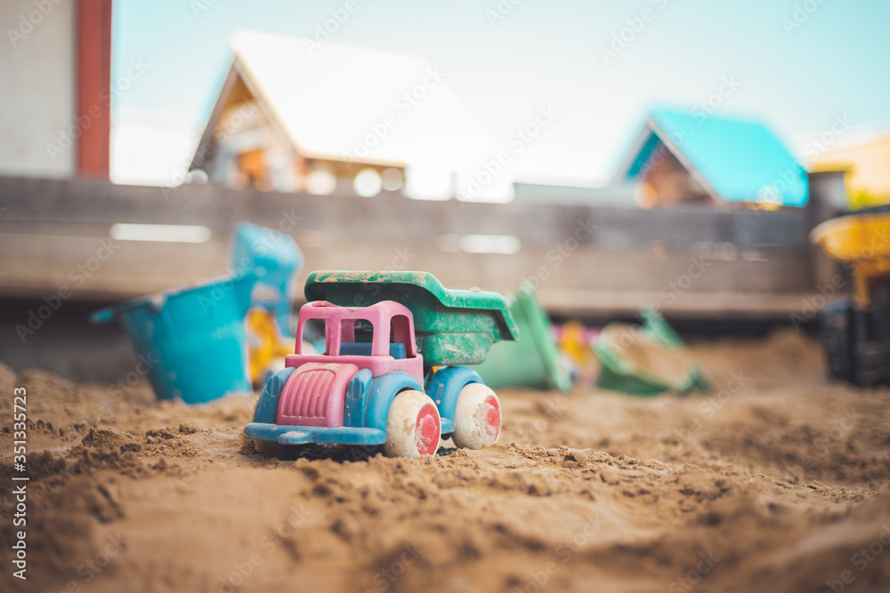 Childhood sandbox concept: Close up of plastic toy truck Childhood sandbox concept: Close up of plastic toy truck