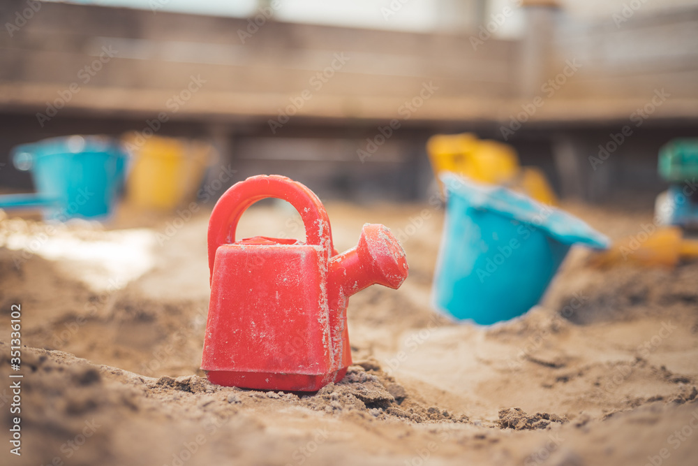 Childhood sandbox concept: Close up of plastic toy watering can Childhood sandbox concept: Close up of plastic toy watering can