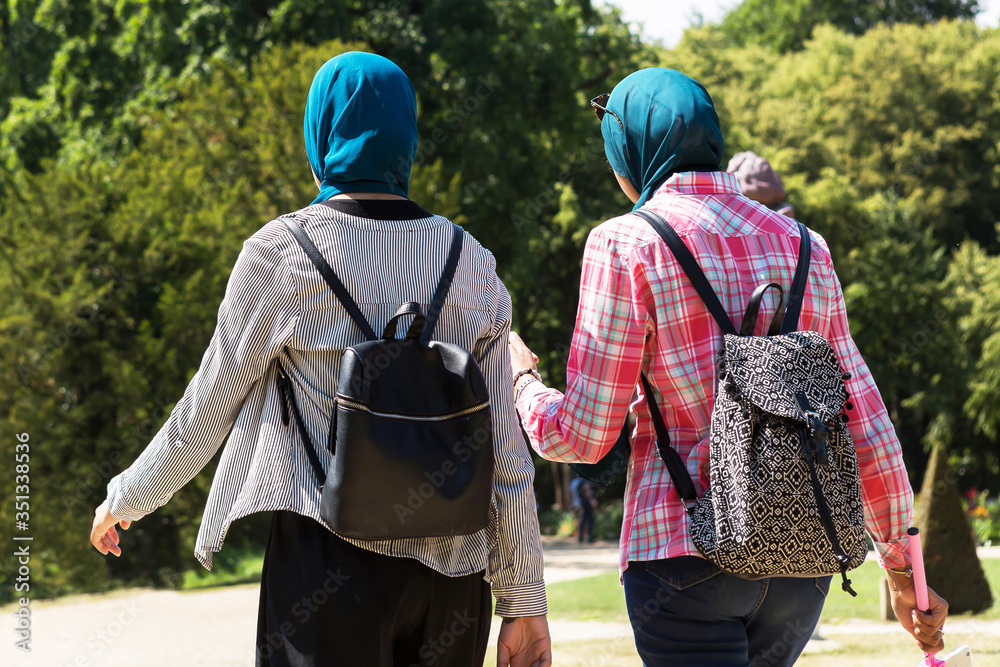 Zwei junge Frauen mit Kopftuch gehen spazieren