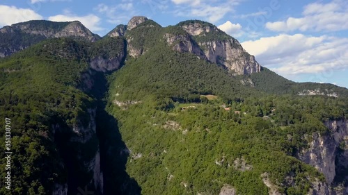 Drone slowly moves in towards a beautiful forested mountain in the European Alps. Stunning view in Trentino, Italy photo