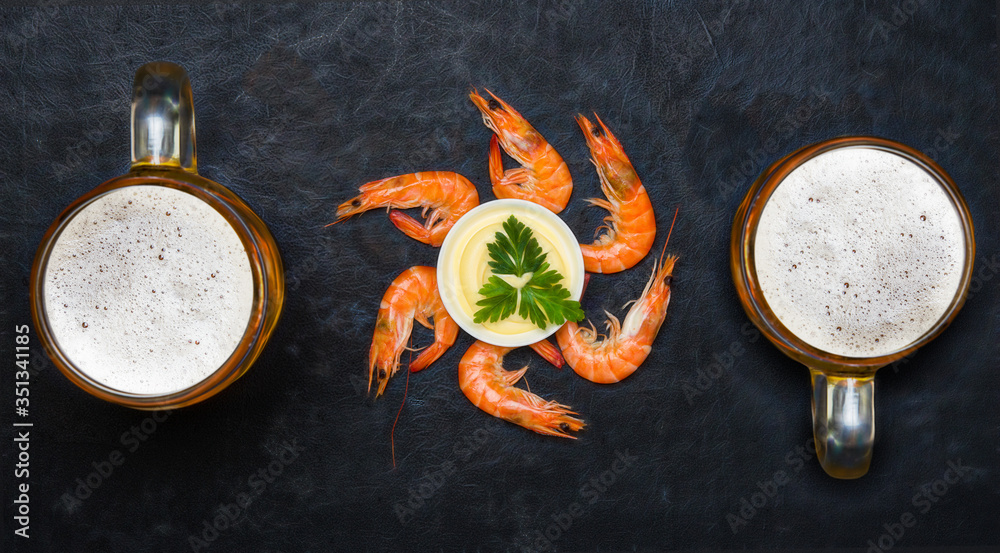 Boiled shrimp with cold beer. Shrimp on a black background. Boiled shrimp with cold beer. Shrimp on a black background.