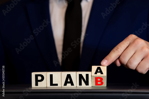 Time for Plan B. Hand is turning a dice and changes the word Plan A to Plan B