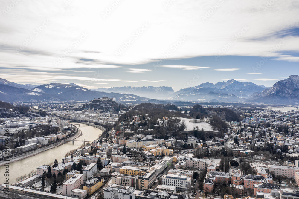 Aerial drone shot view of Salzburg Monchsberg Salzach river and Hohensalzburg fortress Untersberg snow mountain