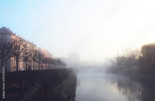 Foggy winter morning at urban riverside photo