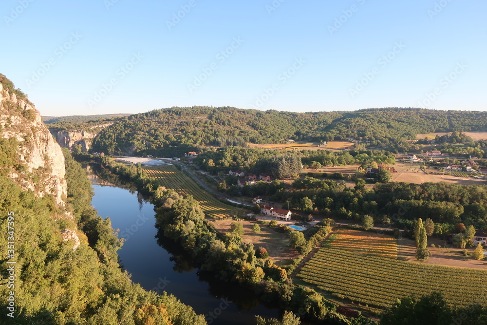 Calm river with green fields in a french medieval village in the countryside 