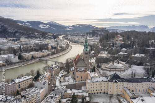 Aerial drone shot view of Salzburg Monchsberg Salzach river and Hohensalzburg fortress Untersberg snow mountain