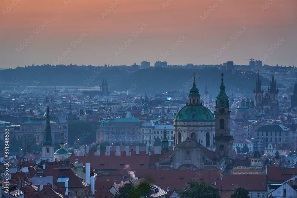 Cityscape of old town with may towers of churches of Prague, capitol of Czech republic during the blue hour before sunset. Main building is Saint Nicolas church on the Lesser Town under the castle.