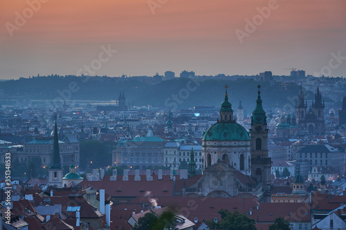 Cityscape of old town with may towers of churches of Prague, capitol of Czech republic during the blue hour before sunset. Main building is Saint Nicolas church on the Lesser Town under the castle.