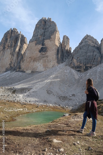 Woman hiker looking at the peak of the italian alps