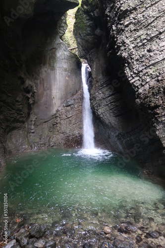 Turquoise waterfall streaming through the rocks in Slovenia photo